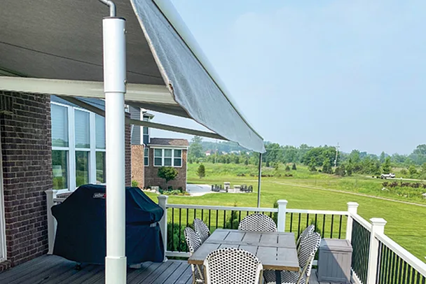 retractable awning over a backyard deck with dining area