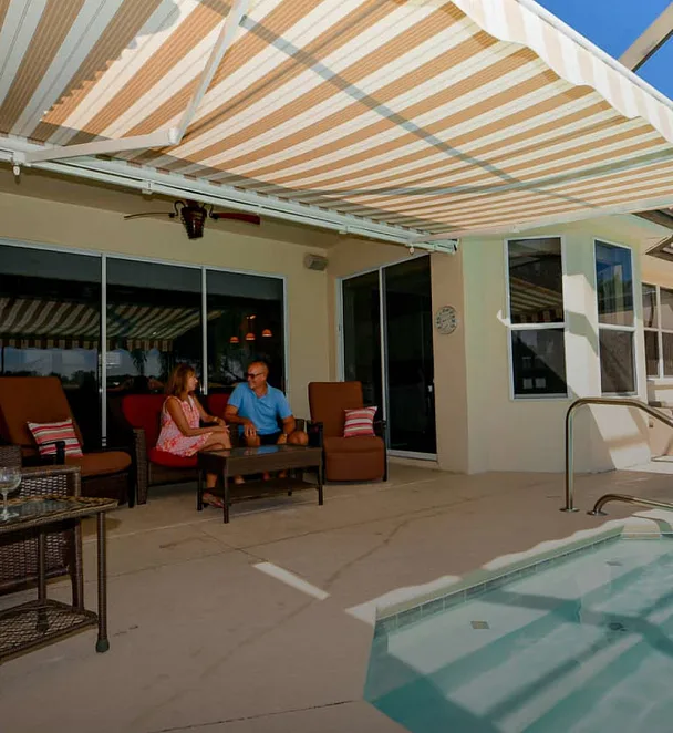 striped retractable awning extended over a poolside patio